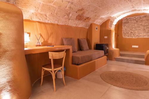 a room with a couch and a table and a chair at Terre Saracene Suites - Elegance Near the Central Station in Bitonto