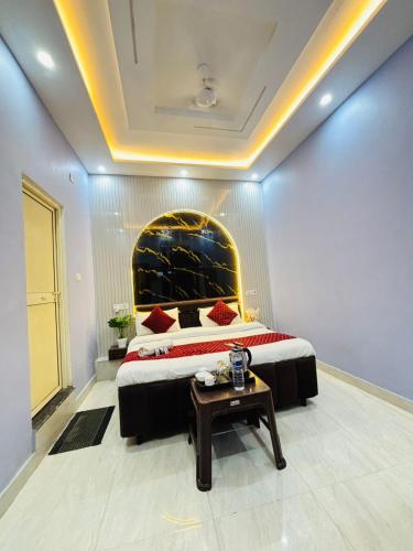 a bedroom with a large bed and a table at Vedas Suites- Saryu Ghat Ayodhya in Ayodhya