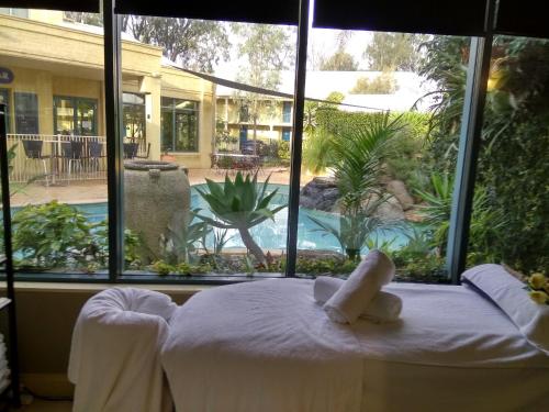 ein Bett in einem Zimmer mit einem großen Fenster in der Unterkunft Madison Spa Motel - Adults Only in Moama