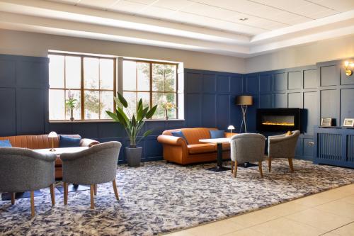 a living room with a couch and a table and chairs at Great National Ballykisteen Golf Hotel in Tipperary