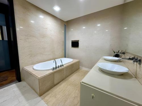 a bathroom with two sinks and a bath tub at Marina Chic l Stylish 2BR Retreat l Straits Quay in Tanjung Bungah