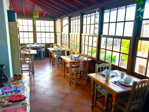 a restaurant with wooden tables and chairs and windows at Ziggy's Mountain Retreat in Vilaflor