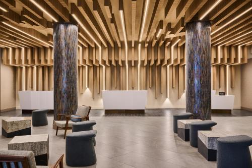 a lobby with two columns and chairs and tables at Hilton Anchorage in Anchorage