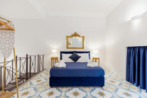 a bedroom with a blue bed and a mirror at Atri Rooms Centro Storico Napoli in Naples