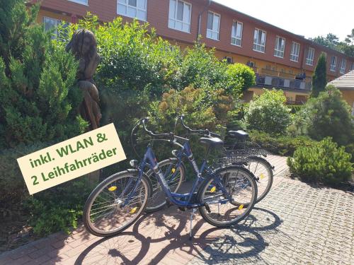 two bikes parked next to a sign in front of a building at Ostseepark in Zempin