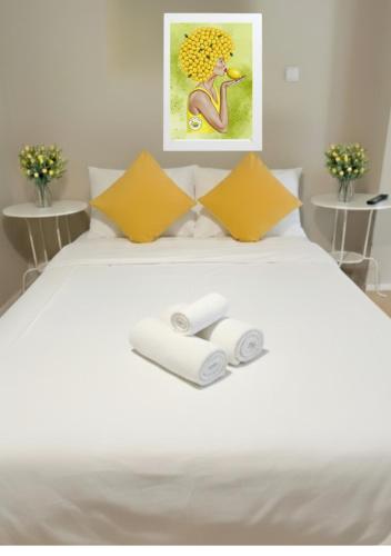 a white bed with two rolls of towels on it at Casa de Limon - צימרים וסוויטות בוטיק בגליל in Sede Eli‘ezer