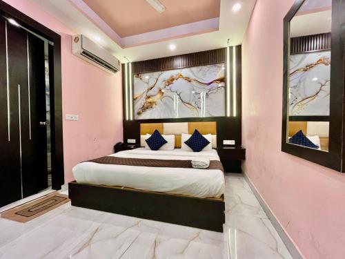 a bedroom with a large bed in a pink wall at Vedas Suites- Saryu Ghat Ayodhya in Ayodhya