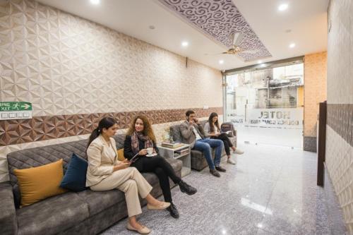 four people sitting on a couch in a waiting room at FabHotel Golden Comforts - Near Shivaji Nagar in Bengaluru