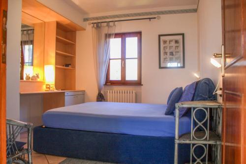 a bedroom with a blue bed in a room at Casa Marica in Porto Valtravaglia
