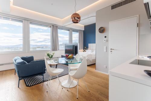 a living room with a table and chairs and a bedroom at Skyline City Loft in Vienna