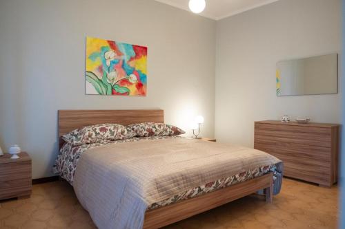 Un dormitorio con una cama y un cuadro en la pared. en Belvedere la Rocca, en Rocca dʼArce