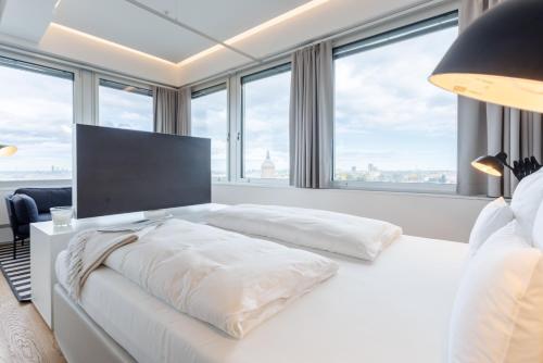 a bedroom with a large white bed with a large window at Exklusives Skyline-View Loft - Nähe Zentrum Wien in Vienna