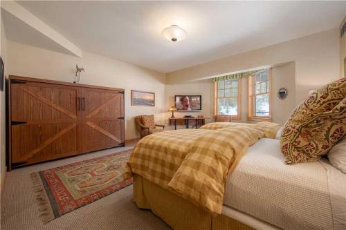a bedroom with a large bed and a wooden door at RMR: Cody House B Condo in Teton Village in Teton Village