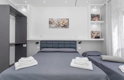a bedroom with two beds with blue sheets at Dolce Relax in Catania