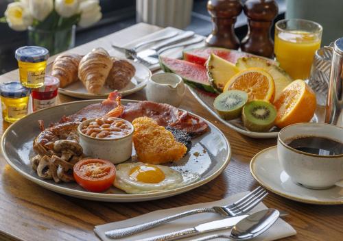 uma mesa com pratos de café da manhã sobre ela em St Nicholas Hotel Colchester em Colchester