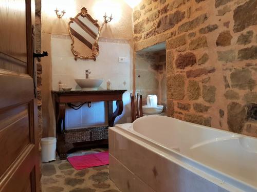 ein Badezimmer mit Badewanne und Waschbecken in der Unterkunft Les Vieilles Treilles in Noailhac