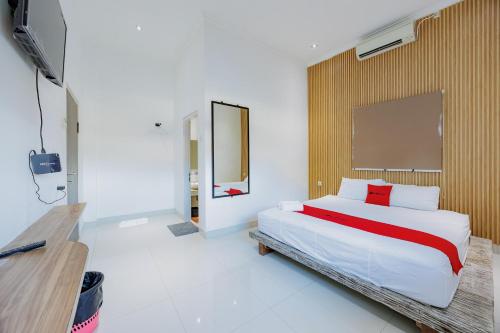 Un dormitorio con una cama grande y un espejo. en RedDoorz near Ubud Village, en Sukawati