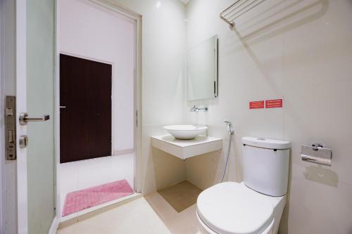 Un baño blanco con inodoro y lavabo. en RedDoorz near Ubud Village, en Sukawati