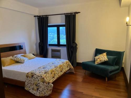 a bedroom with a bed and a chair and a window at Sonho No Mondego in Penacova