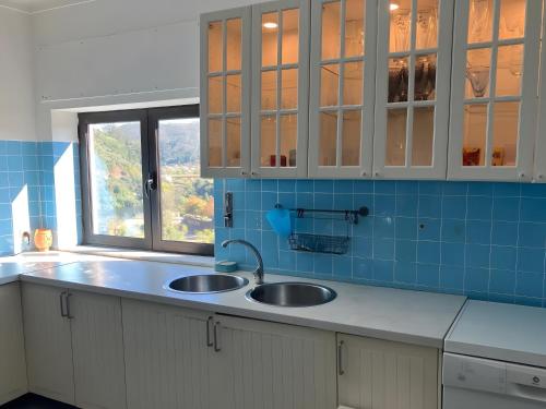 a kitchen counter with two sinks and a window at Sonho No Mondego in Penacova
