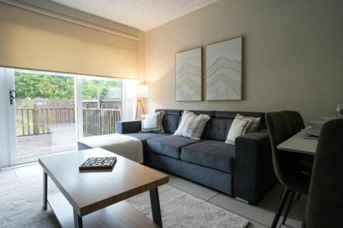 a living room with a blue couch and a table at Stobhill Apartment in Glasgow