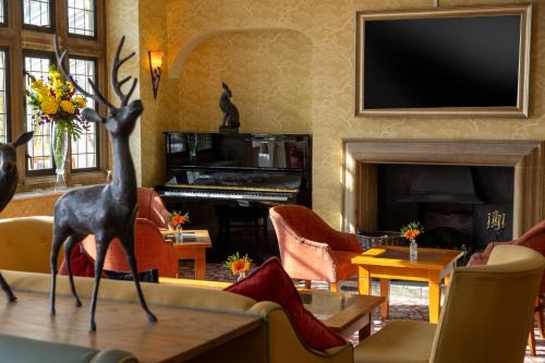 een woonkamer met een open haard en een piano bij Cricklade House Hotel, Sure Hotel Collection by Best Western in Cricklade