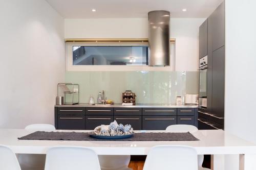 a kitchen with a white table and white chairs at RIVER Apartment in Andermatt