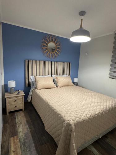 a bedroom with a large bed and a blue wall at Luminoso estudio para 3 personas en Ovalle in Ovalle