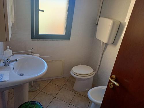 a bathroom with a white toilet and a sink at Da Nanni in Villasimius