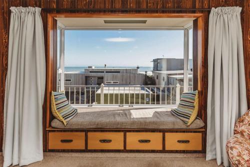 a window seat with a view of the ocean at Beach House On Hamblyn in New Plymouth