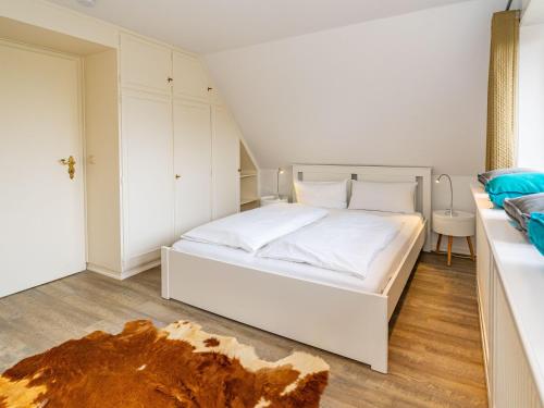 a bedroom with a white bed in a room at Haus-Fahnert-1 in Kampen