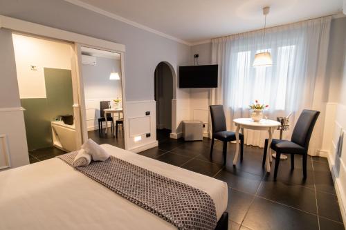 ジュリアーノ・イン・カンパーニアにあるHotel Barbarella Swimmingのベッドとテーブルと椅子のあるホテルの部屋