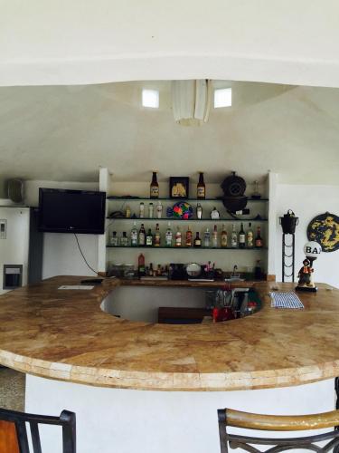a large kitchen with a large wooden counter top at Villa Palmitas acogedor departamento nivel piscina gigante jardines in Acapulco