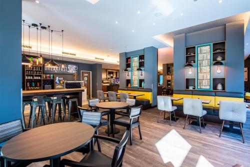 フランクフルト・アム・マインにあるPremier Inn Frankfurt City Centreのテーブルと椅子とバーのあるレストラン