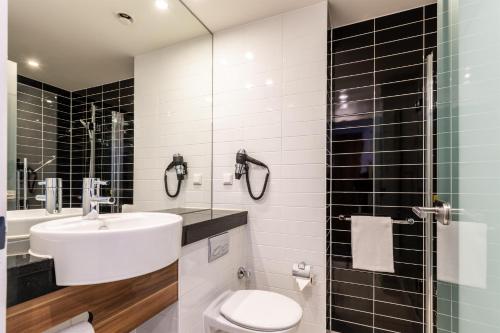 a bathroom with a sink and a toilet and a shower at Premier Inn Frankfurt City Centre in Frankfurt/Main