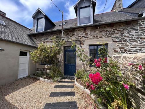 a brick house with a blue door and flowers at Au gré des marées - proche mer in Plérin