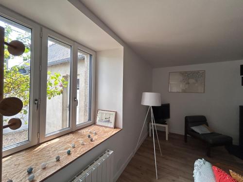 a living room with a window and a chair at Au gré des marées - proche mer in Plérin