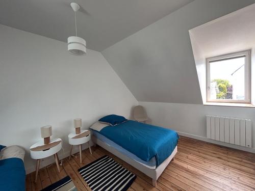 een witte slaapkamer met een bed en een raam bij Au gré des marées - proche mer in Plérin