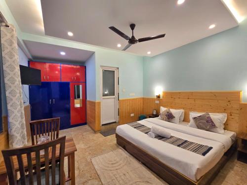 a bedroom with a large bed and a ceiling fan at Aangan Royal Stay in Dharmsala