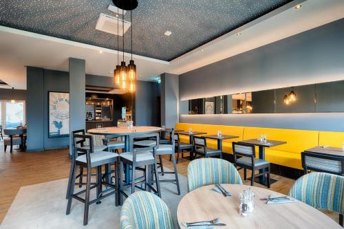 un ristorante con tavoli e sedie e una parete gialla di Premier Inn Lindau a Lindau