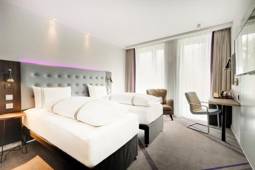 a hotel room with two beds and a desk at Premier Inn Berlin Alexanderplatz in Berlin