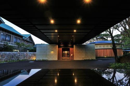 a building under a bridge with a house at AMANE resort GAHAMA in Beppu