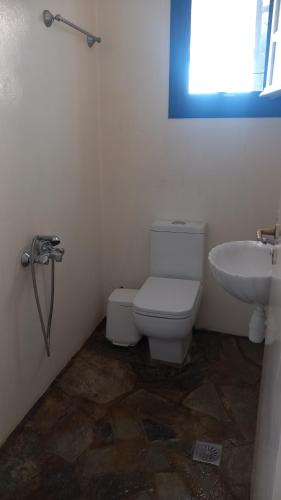 a bathroom with a toilet and a sink at Villa Argos in Agios Georgios