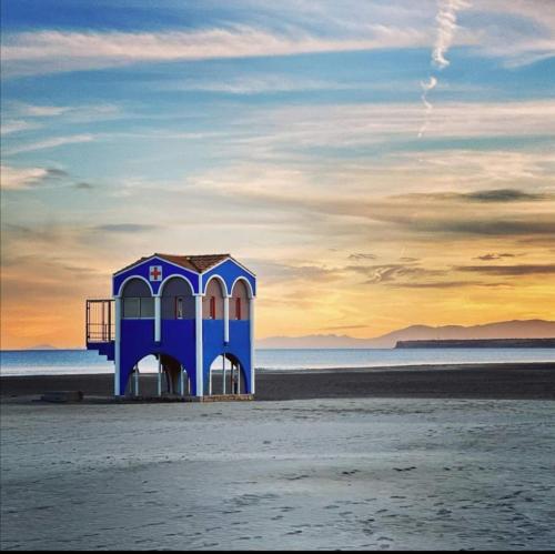 une cabane de sauveteur bleue sur la plage au coucher du soleil dans l'établissement Bord de mer avec piscine intérieure chauffée, à Port-la-Nouvelle