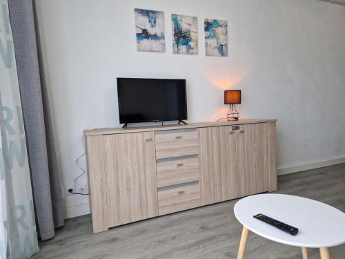 - une télévision au-dessus d'une commode dans la chambre dans l'établissement Bord de mer avec piscine intérieure chauffée, à Port-la-Nouvelle