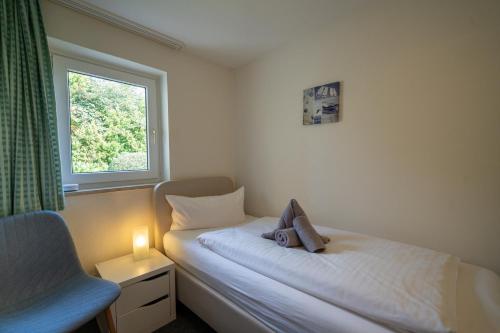 ein kleines Schlafzimmer mit einem Bett und einem Fenster in der Unterkunft Haus Sonnenwinkel Bungalow 8 in Dahme