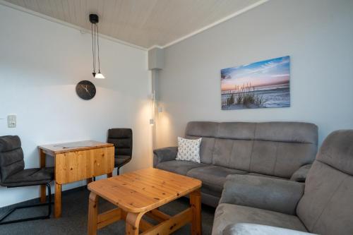 ein Wohnzimmer mit Sofa und Tisch in der Unterkunft Haus Sonnenwinkel Bungalow 8 in Dahme