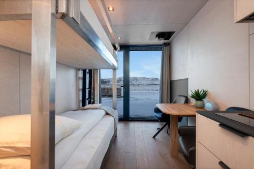 Un dormitorio con una cama, un escritorio y una mesa. en Modern Selfoss Studio, en Selfoss