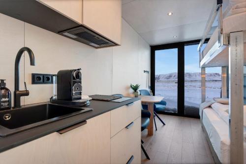 Una cocina con fregadero y una cama en una habitación. en Modern Selfoss Studio, en Selfoss