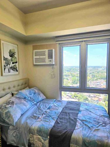 a bedroom with a bed and a large window at Casa Istilo Studio at Avida Abreeza Davao in Davao City